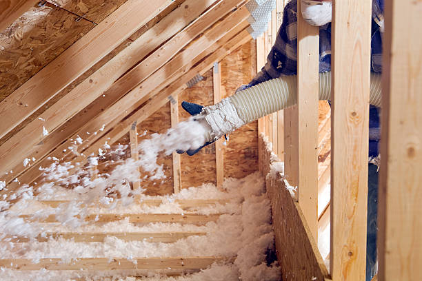 Blown-in cellulose insulation being installed across an attic floor