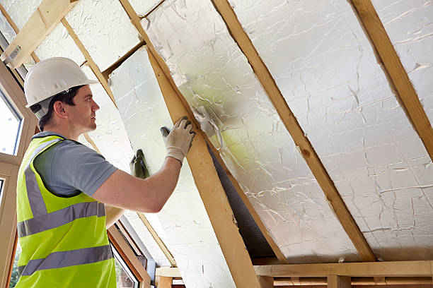 Installer fitting insulation panels beneath a roofline